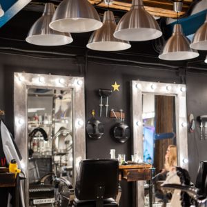 Image of beauty salon interior accented with a mix of metals in the light fixtures and mirrors. 